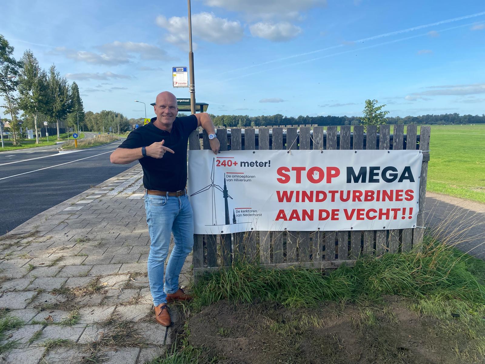 Joost bij het spandoek Stop mega windturbines aan de Vecht